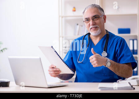 White bearded old doctor working in clinic Stock Photo