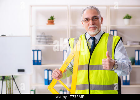 Aged construction engineer working in the office Stock Photo