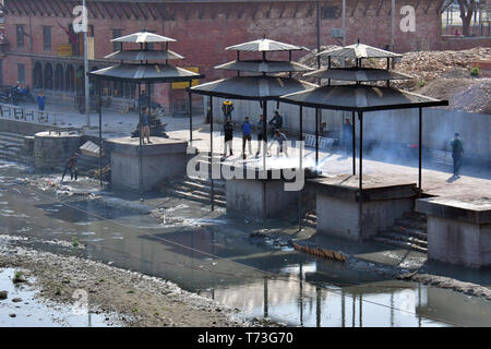 Hindu cremation process in progress near a temple Pashupatinath, Kathmandu, Nepal Stock Photo