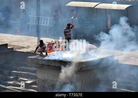 Hindu cremation process in progress near a temple Pashupatinath, Kathmandu, Nepal Stock Photo