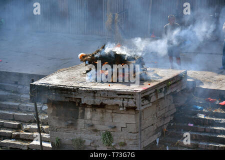 Hindu cremation process in progress near a temple Pashupatinath, Kathmandu, Nepal Stock Photo