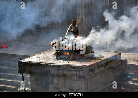 Hindu cremation process in progress near a temple Pashupatinath, Kathmandu, Nepal Stock Photo