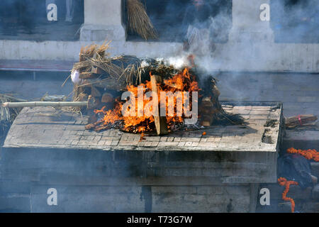 Hindu cremation process in progress near a temple Pashupatinath, Kathmandu, Nepal Stock Photo