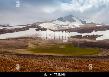 Rainbow-coloured pumice in foreground viewing Mount Katmai in background, Valley of Ten Thousand Smokes, Katmai National Park and Preserve Stock Photo