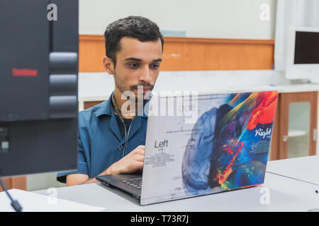 Portrait of Asian university student working on his homework and assignments on his laptop at a computer laboratory Stock Photo