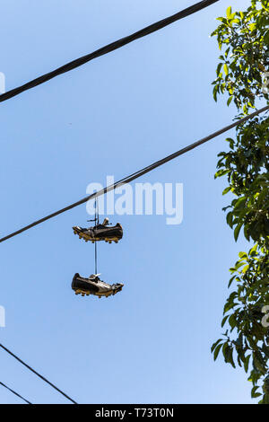 Football cleats hanging from power line on summers day. Stock Photo