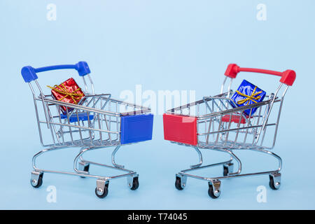 Christmas gifts in a supermarket trolley on a blue background with free space for text Stock Photo