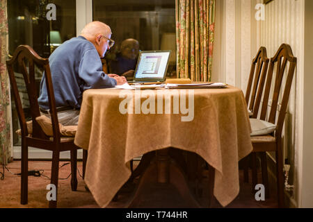 Old man of 93 years having trouble using his computer to check his finances online,very challenging for old people. Stock Photo