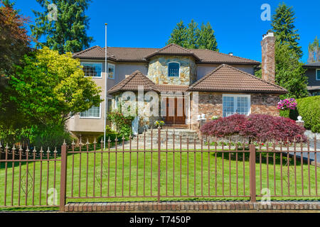 luxury residential house with metal fence in front in suburb of Vancouver Stock Photo