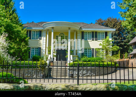 luxury residential house with metal fence in front in suburb of Vancouver Stock Photo