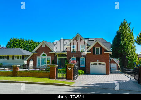 luxury residential house with metal fence in front in suburb of Vancouver Stock Photo