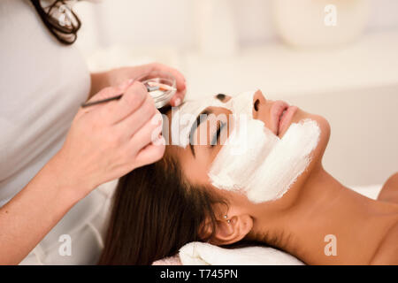 Aesthetics applying a mask to the face of a beautiful woman Stock Photo