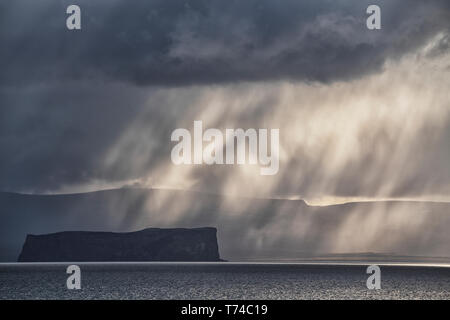 Dramatic light and clouds over the ocean along the North coast of Iceland; Hofsos, Iceland Stock Photo