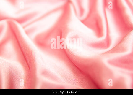 textile and texture concept - close up of crumpled silk pink wavy fabric background Stock Photo