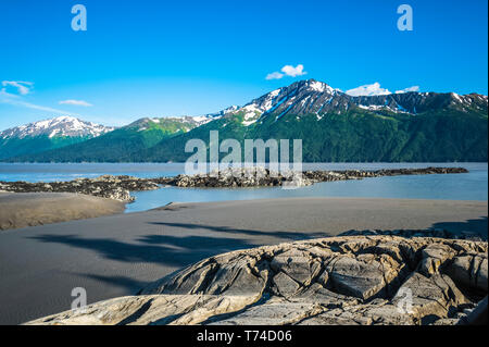 The incoming tide on Alaska's Turnagain Arm portion of the Cook Inlet on a sunny summers day as seen from Bird Point, South-central Alaska Stock Photo