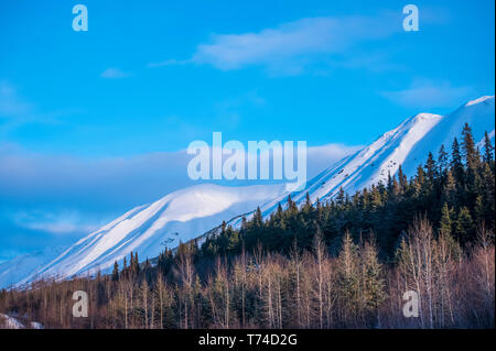 Clouds over mountain tops as daylight fades on the Chugach Mountains in South-central Alaska; Alaska, United States of America Stock Photo