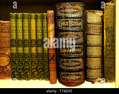 Old leather and cloth bound books on a shelf Stock Photo