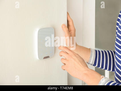 Young man using security system indoors Stock Photo