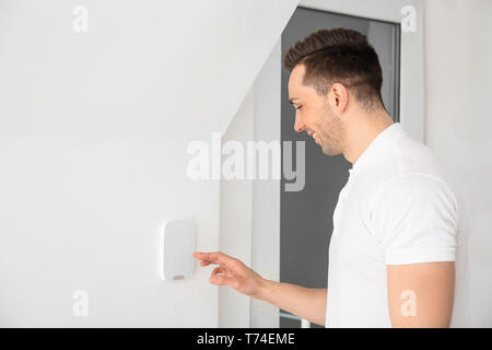 Young man using security system indoors Stock Photo