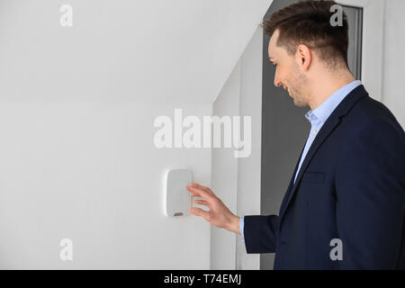 Young man using security system indoors Stock Photo