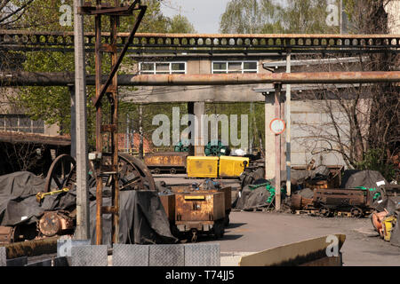Depot of old coal wagons, machines and equipment. Storage on coal mine area, rusty metal constructions, industrial landscape. Katowice, Poland Stock Photo