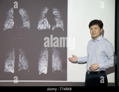 (190504) -- WUHAN, May 4, 2019 (Xinhua) -- Zhou Xin poses for a photo with human lung magnetic resonance images at Wuhan Institute of Physics and Mathematics of Chinese Academy of Sciences in Wuhan, capital of central China's Hubei Province, April 19, 2019. Professor Zhou Xin is the deputy director of Wuhan Institute of Physics and Mathematics of Chinese Academy of Sciences, State Key Laboratory of Magnetic Resonance and Atomic and Molecular Physics, and National Center for Magnetic Resonance in Wuhan. He is interested in ultrasensitive magnetic resonance imaging (MRI) instruments, techniques  Stock Photo