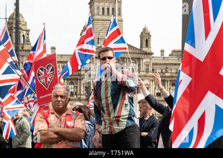 Glasgow, Scotland, UK. 4th May, 2019. Alistair McConnachie, founder of A Force For Good surrounded by Union Jacks speaking in George Square on a day when Glasgow was awash with saltire flags as thousands of demonstrators march in support of Scottish independence Credit: Kay Roxby/Alamy Live News Stock Photo