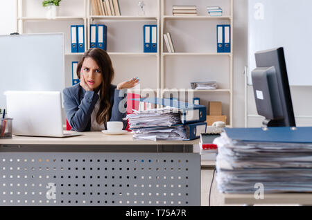 Beautiful female employee unhappy with excessive work Stock Photo
