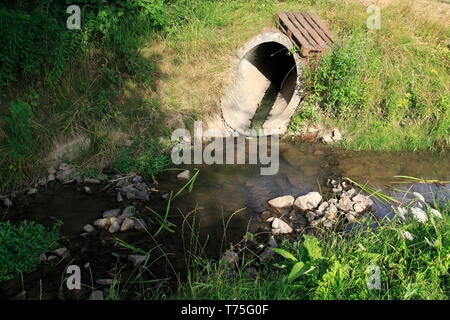 Abwasserkanal, Abflussrohr aus Beton führt Schmutzwasser in einen kleine Bach