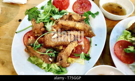 Delicious tasty crispy chicken wings deep fried with spicy crumbed bread spicy herbs chilly tomato slices green lettuce beautiful decoration Stock Photo
