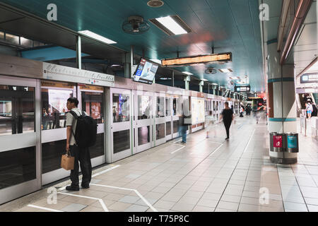 Taipei, Taiwan : People queue up and wait for a metro train at a metro station along the Wenhu line (Brown Line) during the evening rush hour Stock Photo