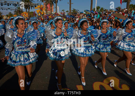 Female members of a Caporales dance group in ornate costumes performing at the annual Carnaval Andino con la Fuerza del Sol in Arica, Chile. Stock Photo
