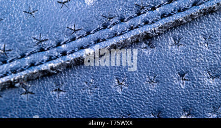 Blue perforated leather texture background. Blue Leather with stitching close up. Macro shot of shiny leather texture. Stock Photo