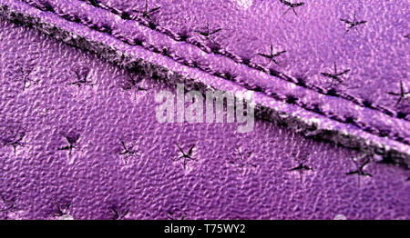 Pink perforated leather texture background. Pink Leather with stitching close up. Macro shot of shiny leather texture. Stock Photo