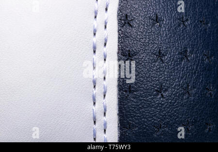 Blue and white perforated leather texture background. White and blue Leather with stitching close up. Macro shot of shiny leather texture. Stock Photo