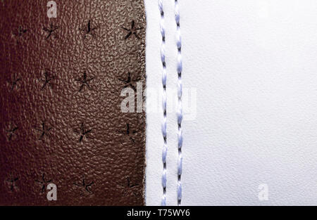 Brown and white perforated leather texture background. White and Brown Leather with stitching close up. Macro shot of shiny leather texture. Stock Photo