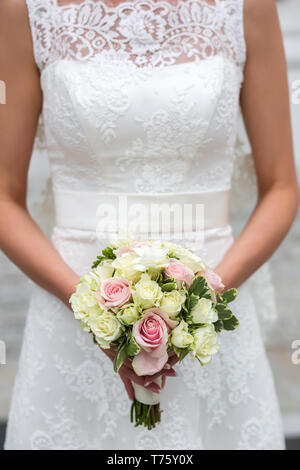 Unrecognizable bride holding a refined wedding bouquet of pink and white roses Stock Photo