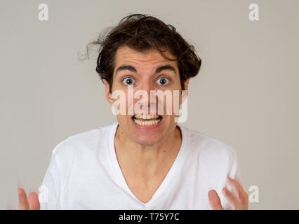 Young man feeling frightened and shocked making scared gestures in fear and anxiety. Terrified and desperate trying to cover himself. Copy space. Peop Stock Photo