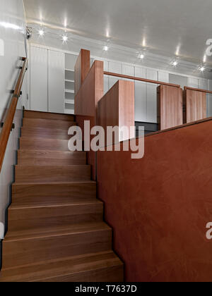 interiors shots of a apartment in the foreground the modern wooden staircase