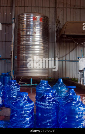 Shrink wrapped potable water bottles await delivery to wholesale customers inside a potable water purification facility in Kampong Cham, Cambodia. Stock Photo