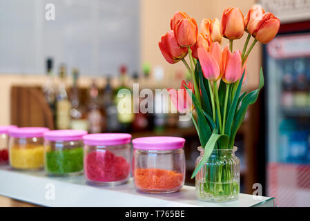 A bouquet of tulips in a vase on the bar counter. Stock Photo