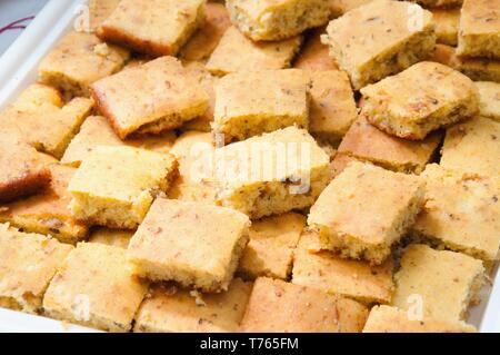 Stacked slices of homemade cornbread. freshly baked,  cut into squares close up top view Stock Photo