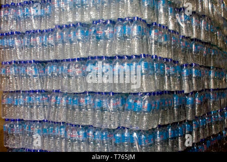 Shrink wrapped potable water bottles await delivery to wholesale customers inside a potable water purification facility in Kampong Cham, Cambodia. Stock Photo