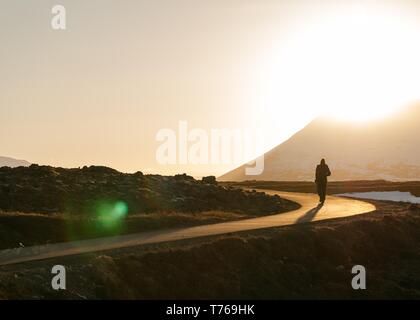 A person walking on a narrow path in the field Stock Photo