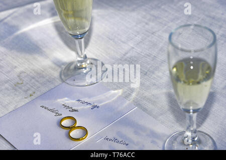 composition with wedding rings and flute of champagne on a wedding invitation Stock Photo