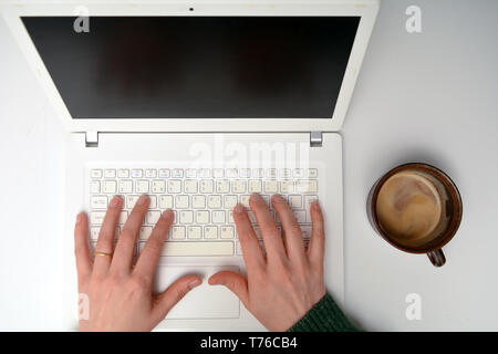 Overhead angle of female entrepreneur businesswoman typing on laptop keyboard, looking down at high angle to hands on computer keyboard Stock Photo