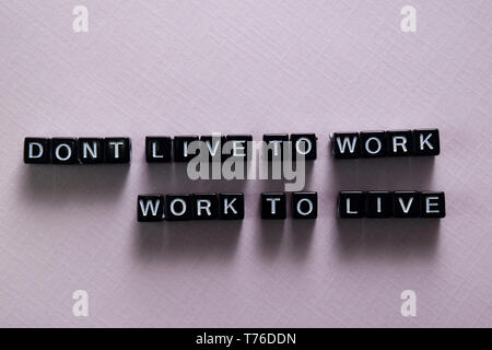 Don't live to work. Work to live on wooden blocks. Motivation and inspiration concept Stock Photo