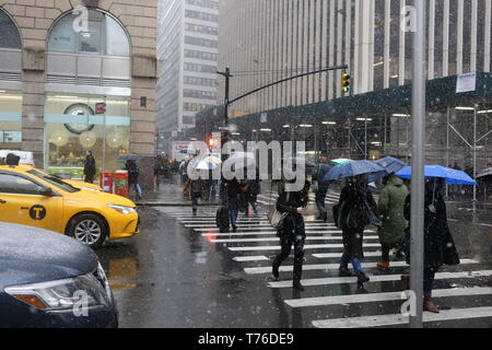 Unidentified people walking in the New York City streets with their umbrellas open in Manhattan, NY Stock Photo