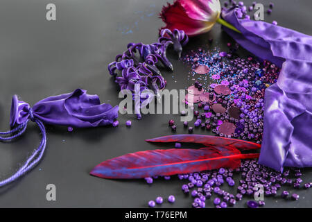 Composition with different items in purple colors on dark background Stock Photo