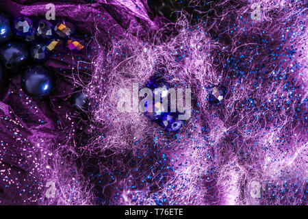 Glitters and beads on purple fibers Stock Photo